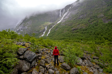 Fototapeta premium Young female hiker enjoying beautiful view of dramatic landscape in a Norway.