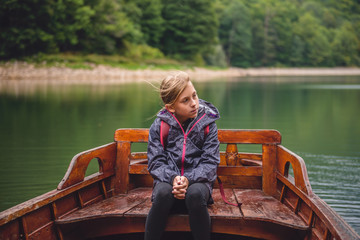 Little girl sitting in a wooden boat