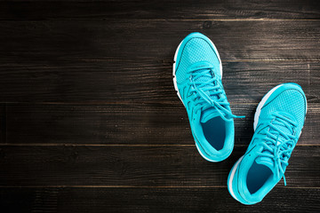 pair of blue sneakers on wooden background.