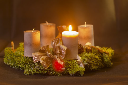 Erster Advent , Adventskranz mit einer brennenden Kerze 