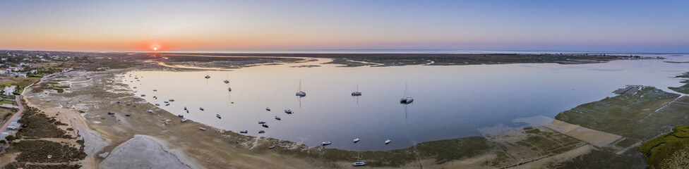 Obraz na płótnie Canvas Sunrise aerial seascape, in Ria Formosa wetlands natural park, shot over Cavacos beach. Algarve.