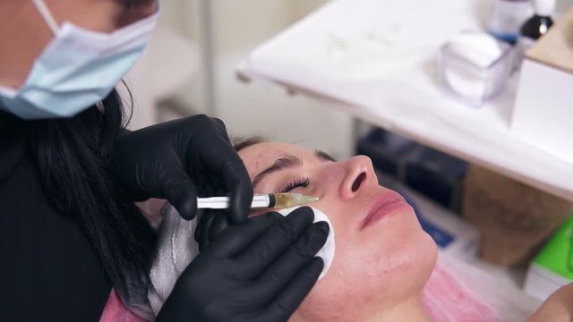 Professional comsetologist in mask making multiple injections in woman's cheek during mesotherapy. Biorevitalization and face lifting, non-surgical medicine treatment