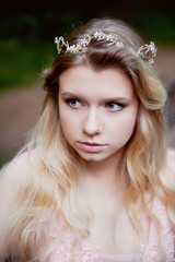 Portrait of beautiful bride blonde in pink lace dress in the hair ornament handmade. Big facial