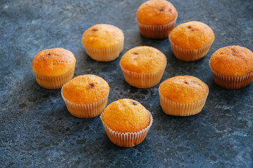 Set of vanilla muffins with chocolate cream filling. Blue stone background.