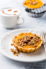 Pumpkin mini pie, tartlet made for Thanksgiving day on gray stone background. Healthy autunm food concept.