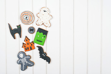 Halloween gingerbread cookies on white wooden table. Top view. Copyspace.