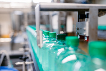 Bottling plant - Water bottling line for processing and bottling carbonated water into green bottles. Selective focus. 