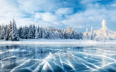 Foto auf Acrylglas Berge Blaues Eis und Risse auf der Eisoberfläche. Gefrorener See unter blauem Himmel im Winter. Die Hügel von Pinien. Winter. Karpaten, Ukraine, Europa.