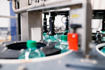 Bottling plant - Water bottling line for processing and bottling carbonated water into green bottles. Selective focus. 