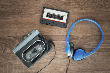 Vintage walkman, cassete and headphones on the wooden background - 172826575