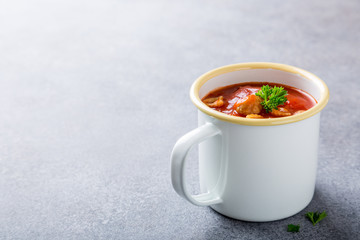 Delicious homemade tomato soup withmeat balls in enamel mug. Healthy food concept with copy space.