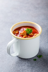 Delicious homemade tomato soup withmeat balls in enamel mug. Healthy food concept with copy space.