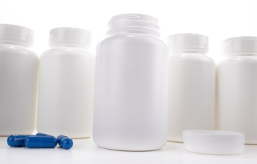 White Pill Bottle Open On Counter Between Cap and Blue Pills