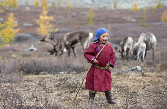 tsaatan boy, dressed in a traditional deel playing outside