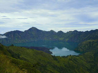 Fototapeta na wymiar Beautiful green crater lake surrounded by green mountains in Rinjani, Lombok, Indonesia
