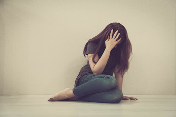 sad woman hug her knee and cry. The depression woman sit on the floor. Teenager girl with...