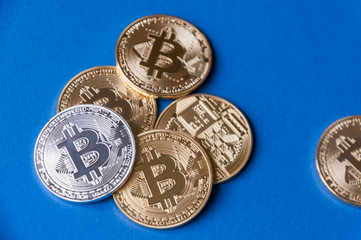 A few gold and silver   coins bitcoin lie on a blue backgroundConcept of crypto currency