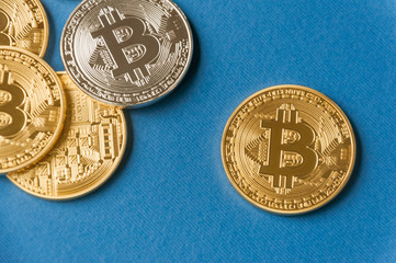 A few gold and silver   coins bitcoin lie on a blue backgroundConcept of crypto currency