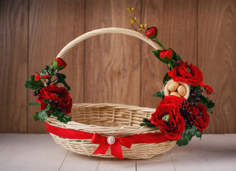 Fototapeta na wymiar Basket with flowers to celebrate Easter on a wooden background