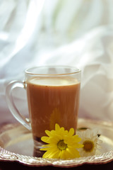Hot coffee, white and yellow chrysanthemums. Morning breakfast with flowers on silver tray, nice blurred background.