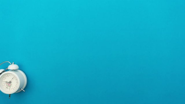4K Time lapse of beautiful colorful alarm clock on blue background