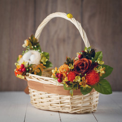 Fototapeta na wymiar basket with flowers to celebrate Easter on a wooden background