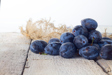 Fresh plums in basket on white background