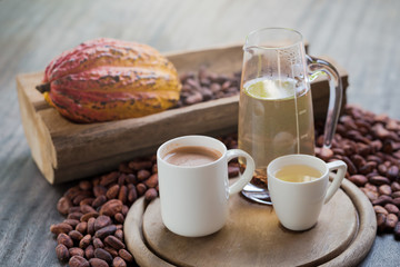 Hot cocoa and milk, Ripe cocoa pod and beans setup on rustic wooden background