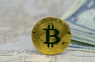 Golden Bitcoins on banknotes background.Photo of golden bitcoin (new virtual currency)
