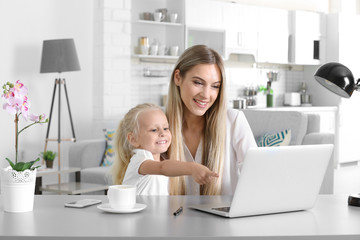 Busy young woman with her daughter at home
