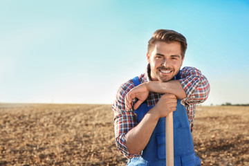 Young male farmer with shovel in field