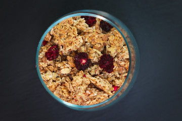 Food breakfast concept Organic Muesli or Granola on black slate stone plate