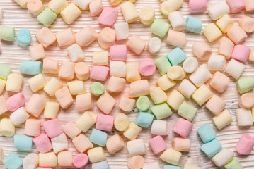 Colorful mini marshmallows on  wooden background