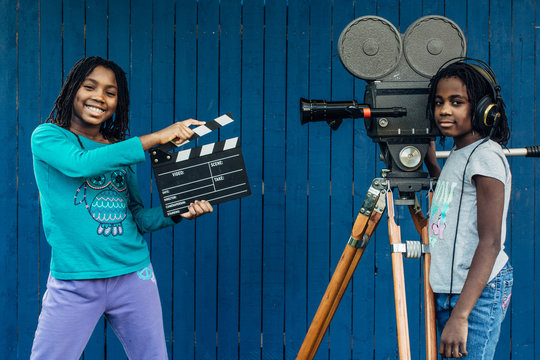 Two black girls playing with an old 16mm film camera