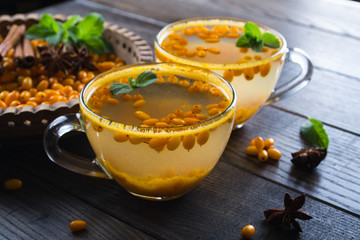 Natural Berry tea with a fresh sea-buckthorn berries and cinnamon sticks, anise stars