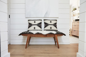Wood bench with pillows in farmhouse hallway