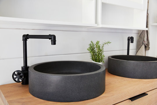 Stone vessel sink on oak vanity in rustic farmhouse bathroom