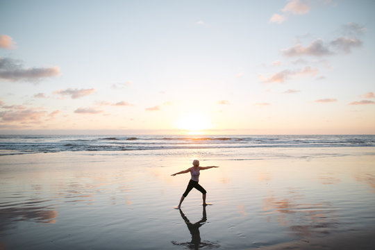 Vibrant mature woman enjoying herself on the beach at sunset