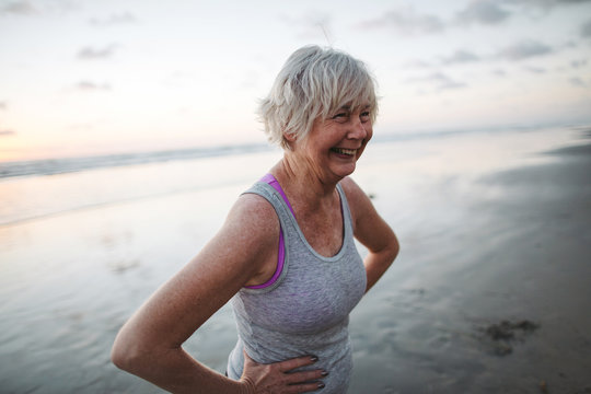 Active senior woman on beach at sunset