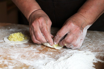 Female hands making dough for pizza