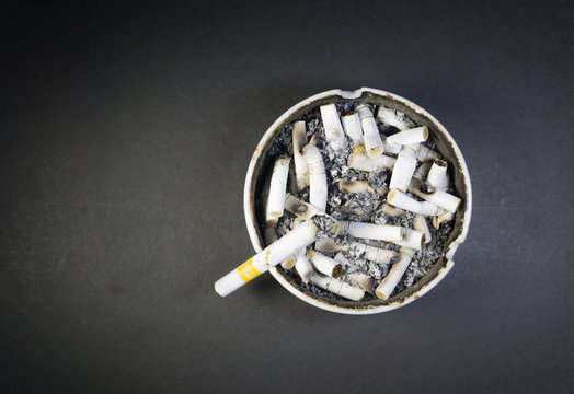 Isolated cigarette ashtray with cigarette kretek burning