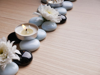 Fototapeta na wymiar Spa still life concept,Close up of spa theme on wood background with burning candle and bamboo leaf and flower