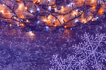Christmas background with colorful garland and snowflakes purple color.