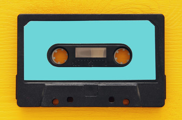 Retro cassette tape over yellow wooden table. top view. copy space
