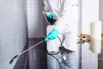Exterminator In Work Wear Spraying Pesticide With Sprayer