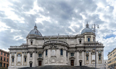 Facade of the papal Basilica called Santa Maria Maggiore, without people in sight and with a blue sky with very light clouds. In the square called "Esquilino" in Rome, Italy