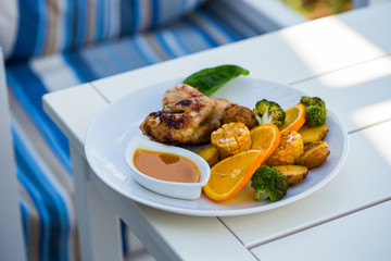 chicken with corn and potatoes in a plate on the table