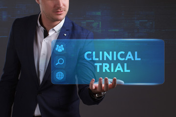 Business, Technology, Internet and network concept. Young businessman working on a virtual screen of the future and sees the inscription: Clinical trial