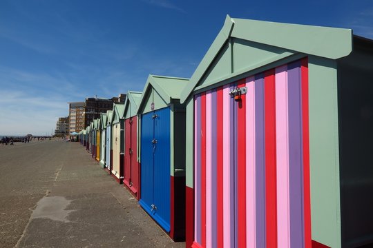 Colorful painted beach huts in a row on Brighton and Hove boardwalk in England, UK
