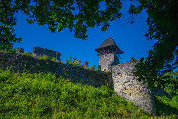 Fototapeta premium Stone fortification on green hill on blue sky